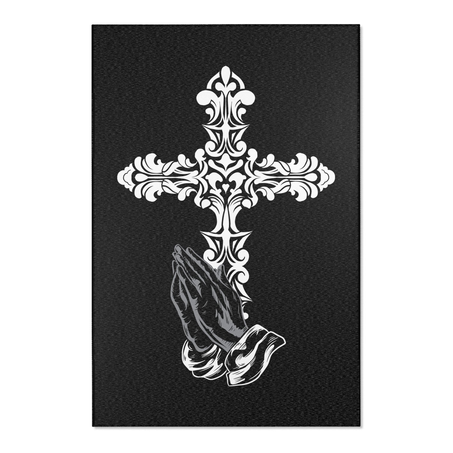 A rectangular area rug with a floral cross design above a praying hands motif on a dark background.